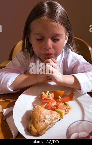 Girl praying before dinner Stock Photo