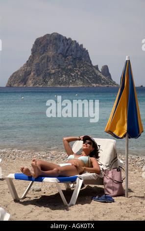 Young woman on a deck chair at the beach in Cala de Hort, Ibiza, Spain Stock Photo