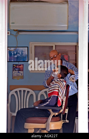 Israel Tel Aviv Jaffa old style barber in his shop shaving a customer Stock Photo