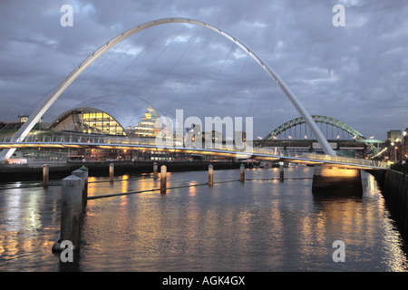 Gateshead Millennium Bridge over River Tyne in North East England. Sage Concert Hall to left & Tyne Bridge in distance.