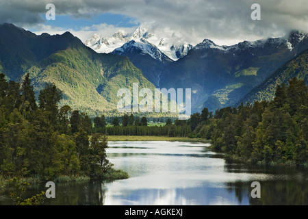New Zealand, South Island. Cloud-shrouded Mt. Cook is reflected in Lake Matheson near the town of Fox Glacier. Stock Photo
