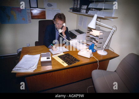 Business Man Sitting At Desk Using Telephone Stock Photo