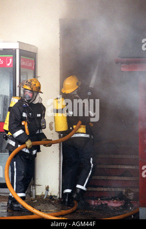 Two Firefighters enter a burning building, Britain UK Stock Photo