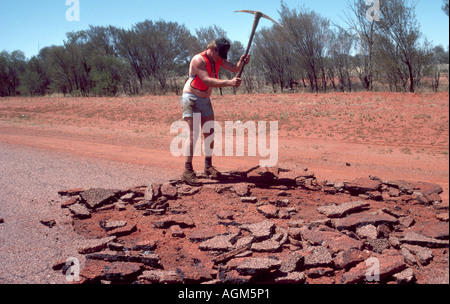 Northern Territory Australia Road Worker Using Pickaxe To Break Up Road Stock Photo