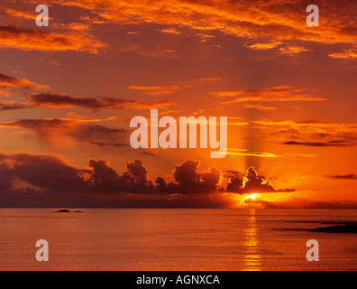 Stunning red sky at sunset with sunbeams through clouds over Firth of Lorn on Scottish west coast at sundown. Argyll & Bute Scotland UK Britain Stock Photo
