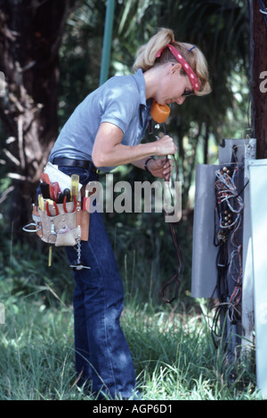 Woman telephone technician checking phone lines at switchbox on Siesta Key in Sarasota Florida USA Stock Photo