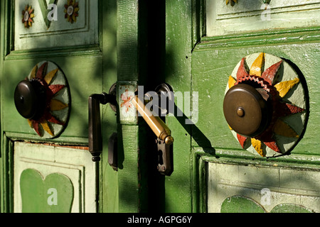 vintage doorknob (door handle, door latch) and doorbell on a green painted door Stock Photo