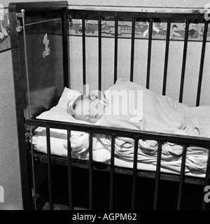 OLD VINTAGE FAMILY PHOTOGRAPH SNAP SHOT BABY GIRL SLEEPING IN NURSERY COT Stock Photo