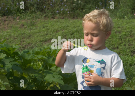 Child blows bubbles Stock Photo