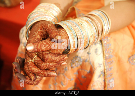 Indian Gujarati bride painted hands with mehndi mehandi henna heena and bangles for wedding marriage ceremony India Stock Photo