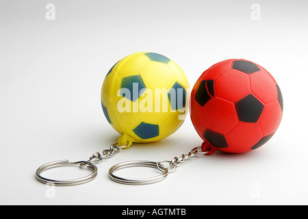 Keychains two small red and black bouncing rubber football shape sport balls on white background Stock Photo