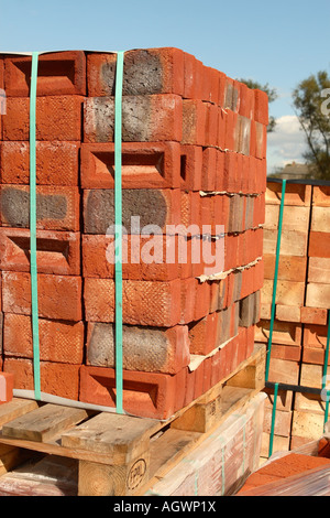 Brick stack of new red bricks on pallet in builder merchant supplier yard Stock Photo