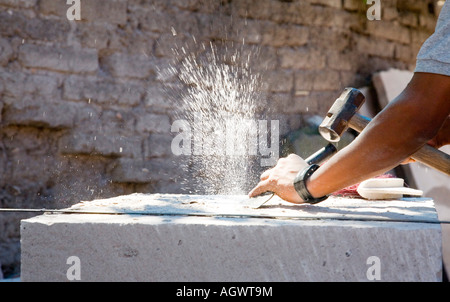 Hispanic stone carving workers using hammers and chisels Stock Photo