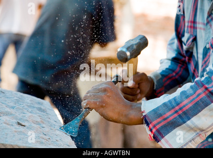 Hispanic stone carving workers using hammers and chisels Stock Photo