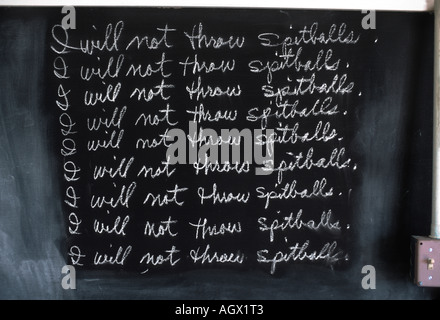 Classroom chalkboard with repeated writing of I will not throw spitballs as a disciplinary measure Stock Photo