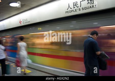 Commuters wait on the platform for a train at People's Square Metro station. Shanghai Metro system is cheap clean and efficient. Stock Photo