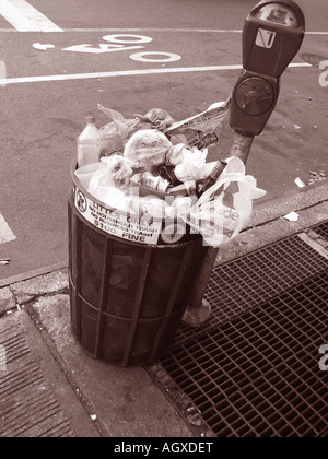 Trash can full, overflowing on the sidewalk in New York City sepai toned photograph Stock Photo