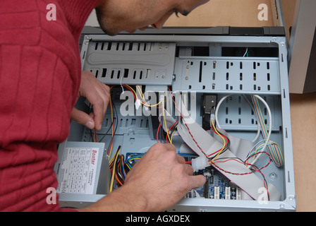 Male computer technician working on the inner parts of a PC Stock Photo