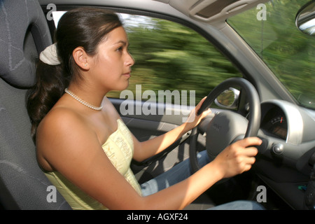 Young woman driving Smart Car checking rear vision mirror, Stock Photo