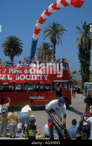 Red London style double decker bus passes under arch of balloons during July Fourth Parade in Westchester, Los Angeles Stock Photo