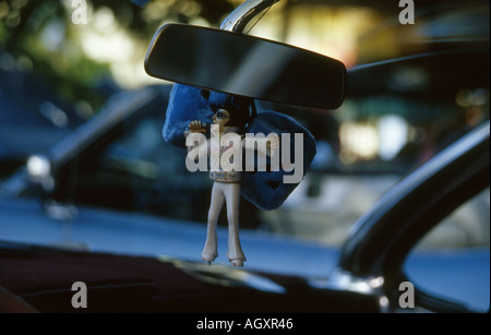 elvis model and dice hanging from mirror in car Stock Photo