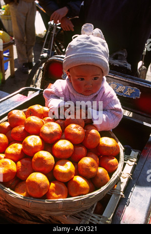 China Yunnan Lijiang Market child on orange stall Stock Photo