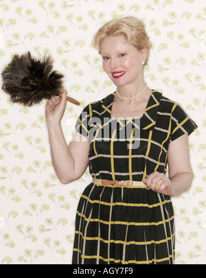 Woman holding a feather duster Stock Photo