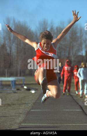 Female track and field athlete long jumping into sand Stock Photo - Alamy