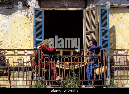 Couple having a coffee on the balcony of their half destroyed house located on the old green line in Beirut Lebanon Stock Photo