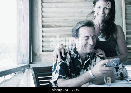 Mid adult man holding a digital camera with a mid adult woman beside him Stock Photo