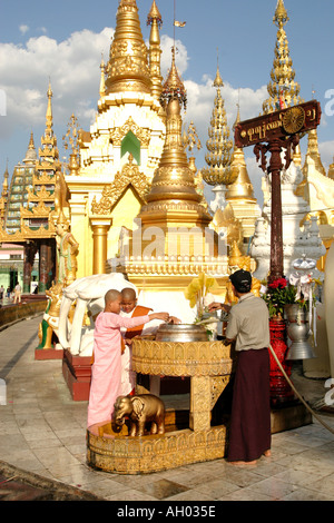 Nat worship young nuns earning merit at a Nat in the Shwedagon complex Yangon Mayanma Burma Stock Photo