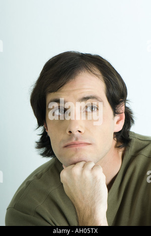 Man resting chin on hand, looking away, portrait Stock Photo