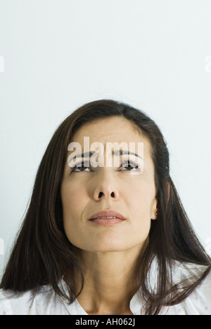 Woman furrowing brow, looking up, portrait Stock Photo