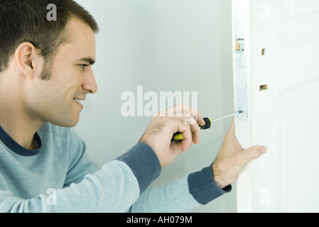 Man removing lock from door Stock Photo