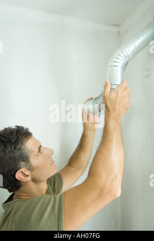 Man installing air duct Stock Photo