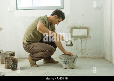 Man applying plaster around air vent Stock Photo