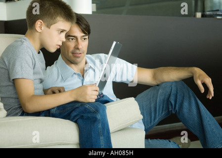 Father and son using laptop together Stock Photo