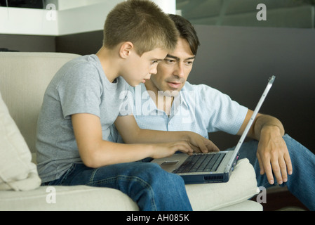 Father and son using laptop together Stock Photo