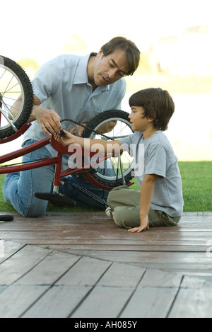 Father and son fixing bike together Stock Photo