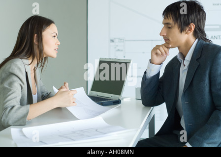 Man consulting female architect about blueprints Stock Photo
