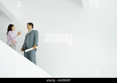 Young woman standing speaking with architect, low angle view Stock Photo