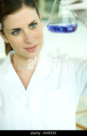Female lab worker holding up flask Stock Photo