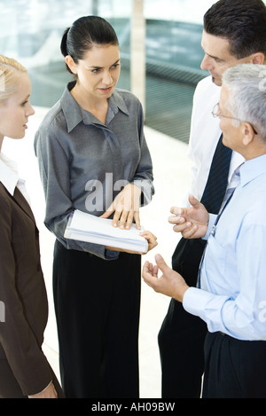 Business associates standing together, discussing, high angle view Stock Photo