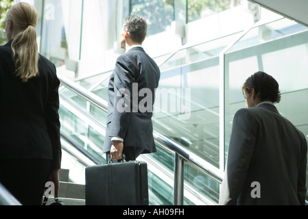 Business associates walking up stairs, rear view Stock Photo