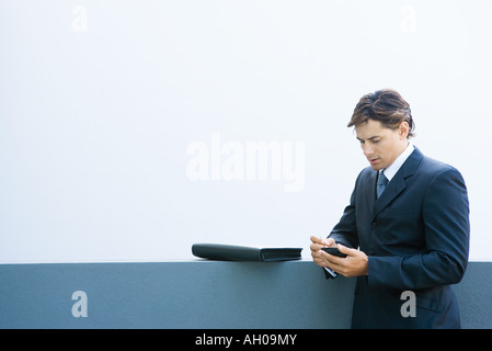 Young businessman using palmtop, looking down Stock Photo