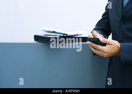 Businessman using palmtop, side view, cropped view of hands Stock Photo