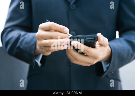Businessman using palmtop, cropped view Stock Photo