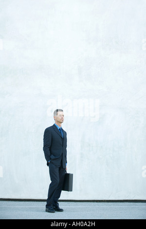 Businessman standing, looking away, full length portrait Stock Photo