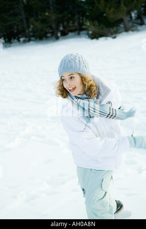Teenage girl running in snow, looking away, blurred motion Stock Photo