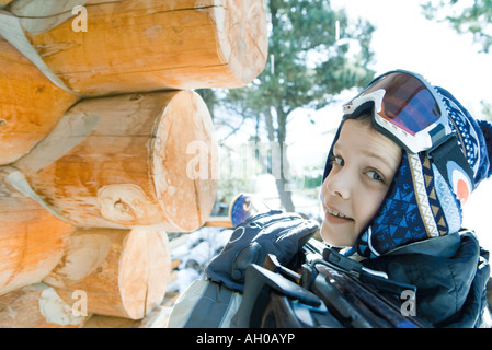 Boy holding skis on shoulder, smiling over shoulder at camera Stock Photo